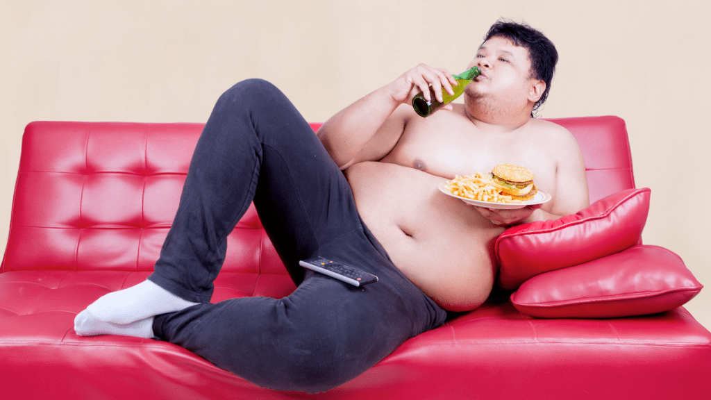 ソファに横になってコーラとポテチを食べる太った人